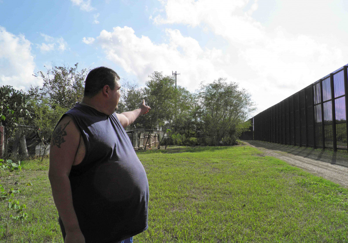 Ernest Villarreal points to where the U.S. border fence passes through the backyard of his family's home in Brownsville, Texas, U.S. on November 18, 2016. REUTERS/Jon Herskovitz