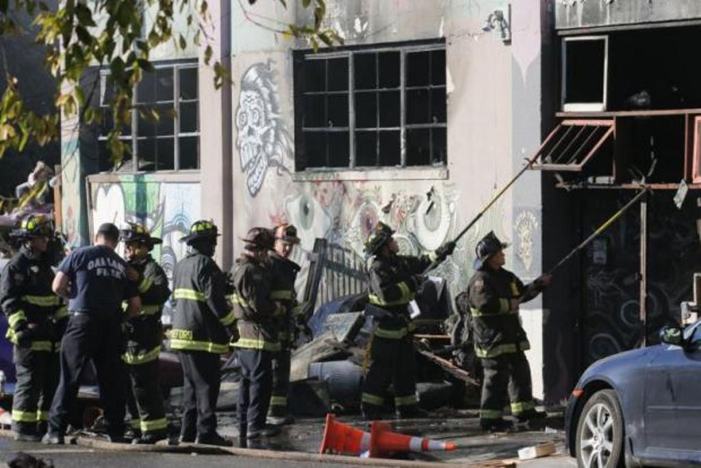 Firefighters work to clear the debris from a doorway following an overnight fire at a warehouse in the Fruitvale neighbourhood on Saturday in Oakland, California. (AFP photo).