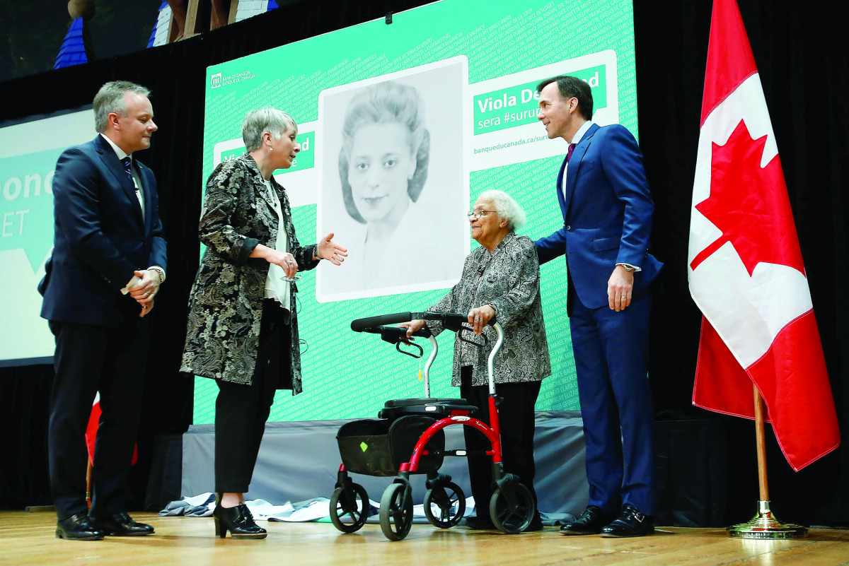 Canada's Finance Minister Bill Morneau (right) stands with Wanda Robson after her sister and rights activist Viola Desmond was chosen to be featured on a new $10 bank note during a ceremony at the Museum of History with Governor of Bank of Canada Stephen 