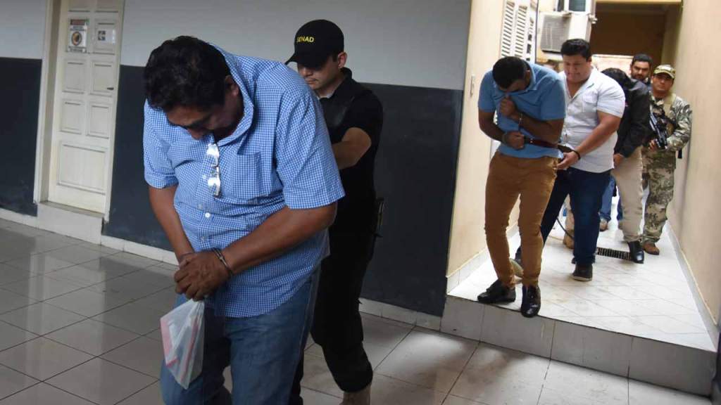 Mexican Martin Huerta (L) is taken into custody by police after declaring in Asuncion on December 9, 2016. Four Mexicans presumably linked to the Sinaloa cartel were arrested Thursday, among them Waine Gallien, pointed as a cartel leader and 308kg of coca