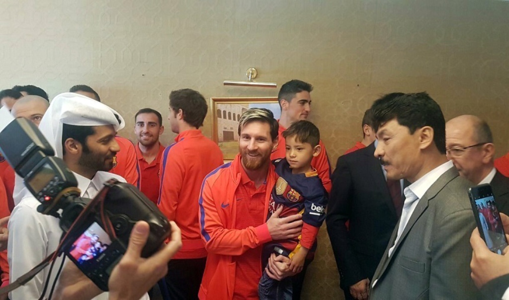 A handout picture released by Qatar?s Supreme Committee for Delivery and Legacy on December 13, 2016 shows Barcelona's Argentinian forward Lionel Messi (C-L) holding six-year-old Afghan boy Murtaza Ahmadi (C-R) in Doha