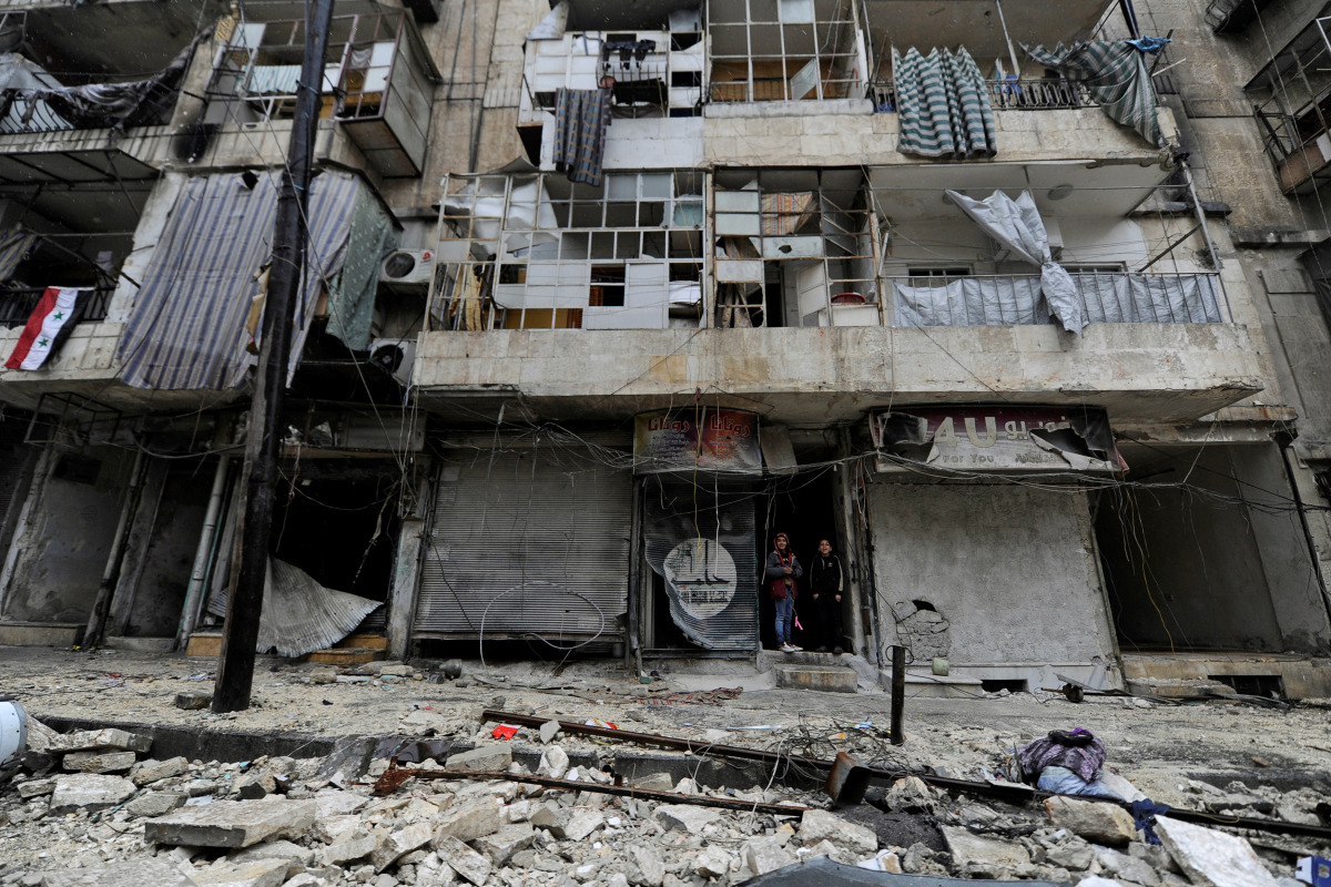 Boys stand amid the damage in the government-held al-Shaar neighborhood of Aleppo, during a media tour, Syria December 13, 2016. REUTERS/Omar Sanadiki
