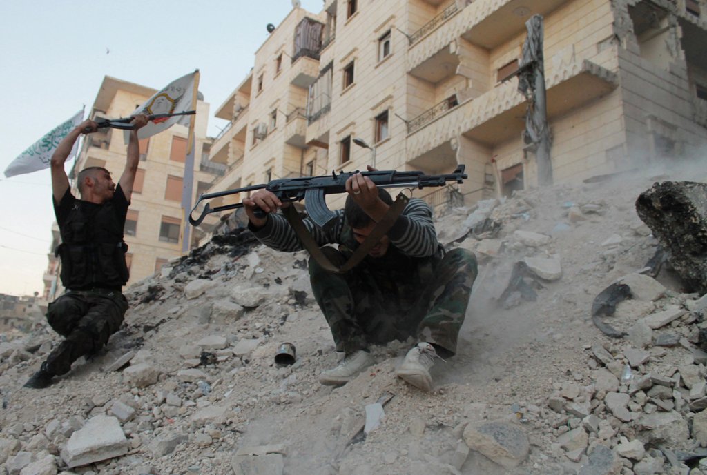 Free Syrian Army fighters fire their weapons during what the FSA said were clashes with forces loyal to Syria's President Bashar al-Assad in Aleppo's Karm al-Jabal district October 15, 2013. REUTERS/Mohamed Mounzer Masri
