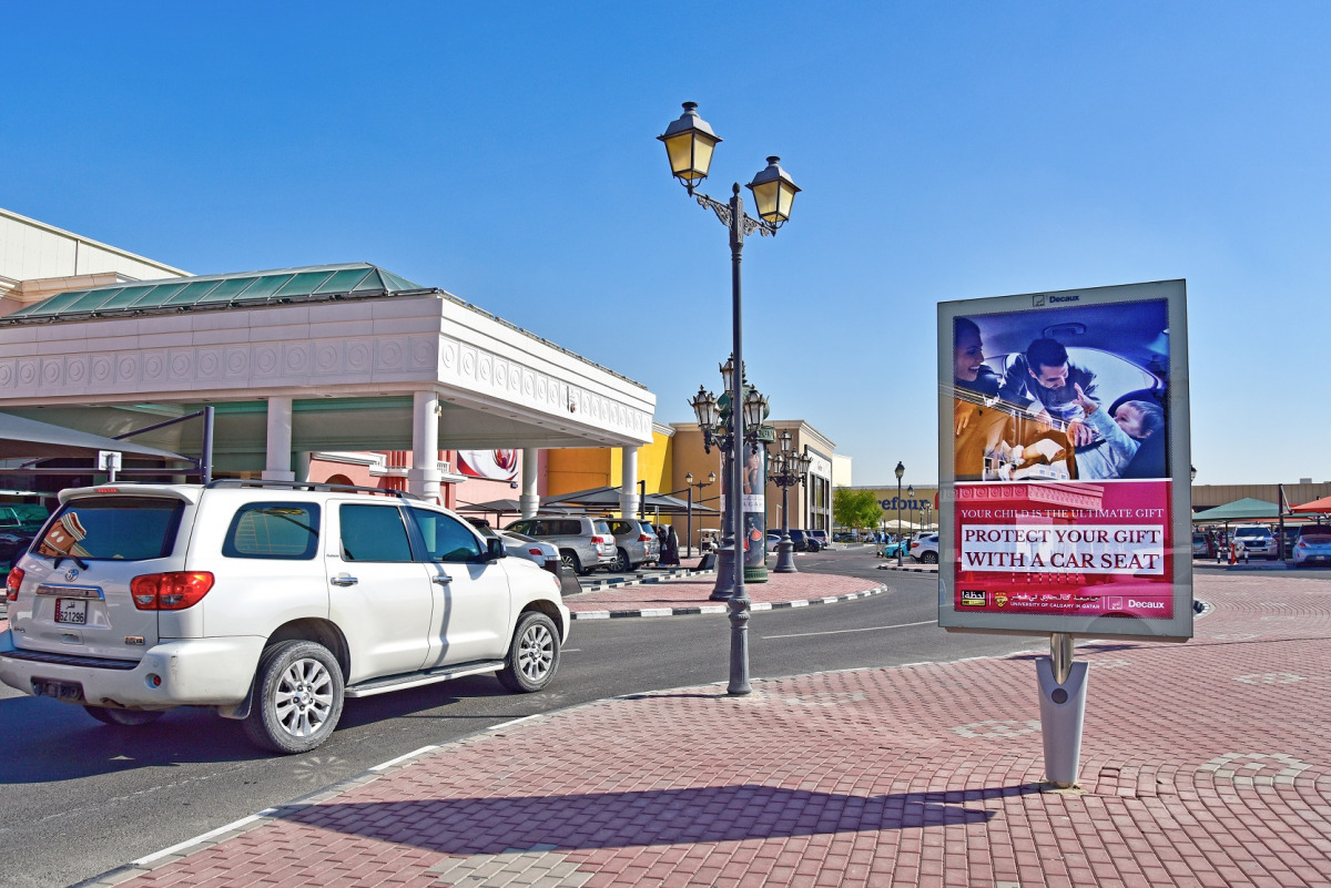 An advertisement displayed on a street to create awareness about the importance of child car seat usage.