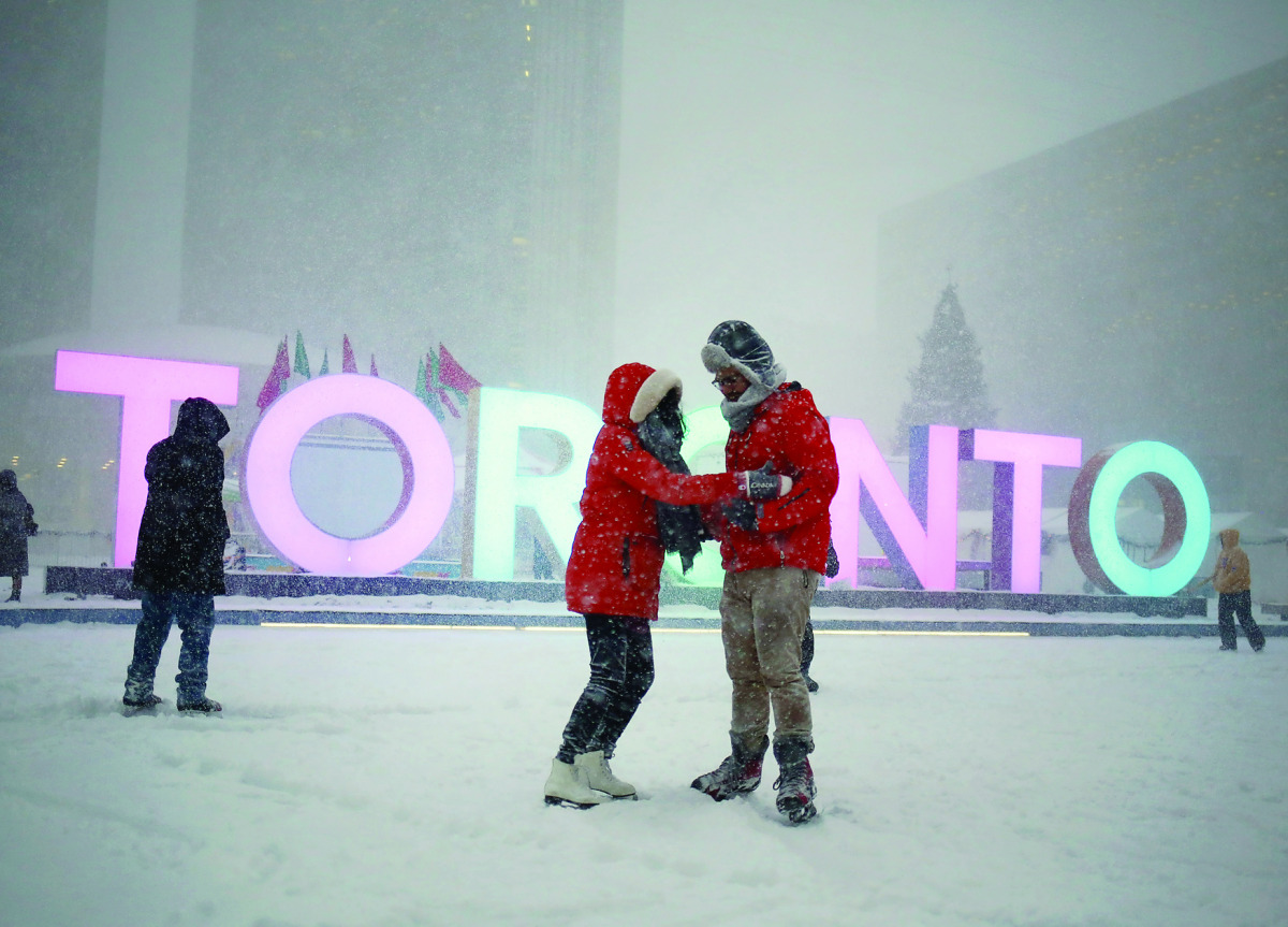 A couple skates during a snowstorm on an outdoor rink at city hall in Toronto, Canada, yesterday.