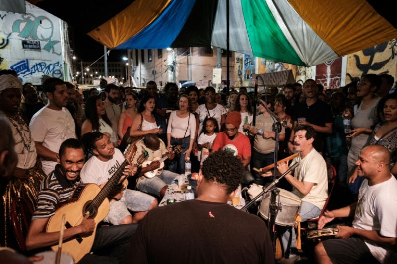 Surrounded by a mostly young crowd, seven musicians sit around a table with the small four-string guitar called a cavaquinho, the cuica drum and a tambourine. AFP