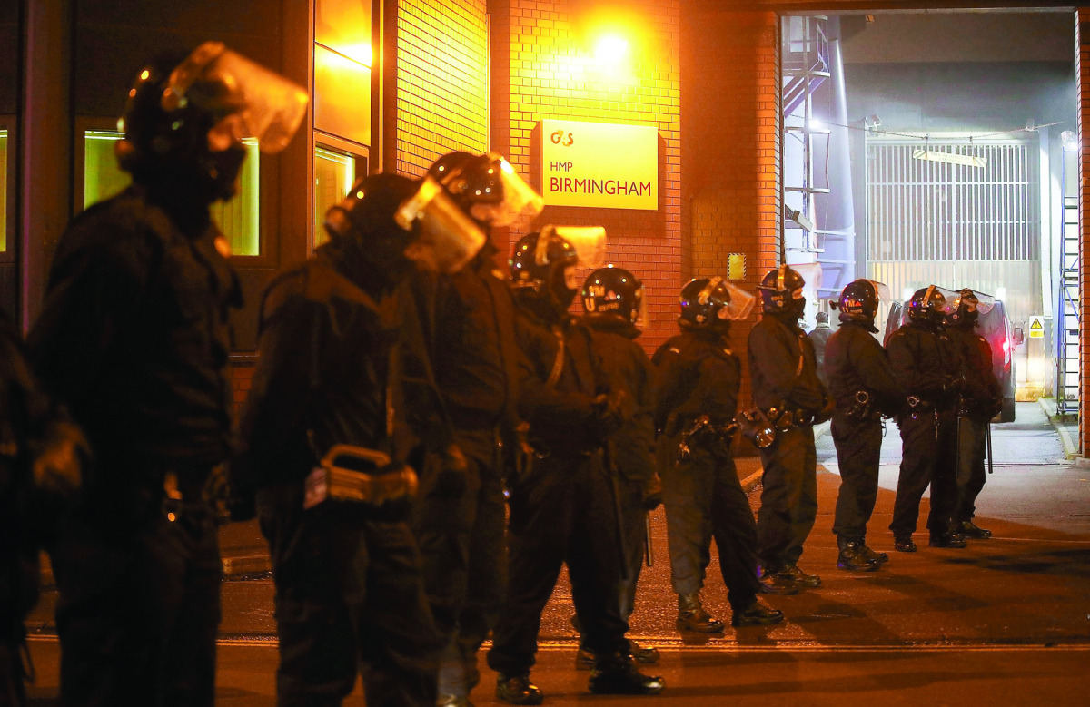 Police officers in riot gear stand outside Winson Green prison, run by security firm G4S, after a serious disturbance broke out, in Birmingham.