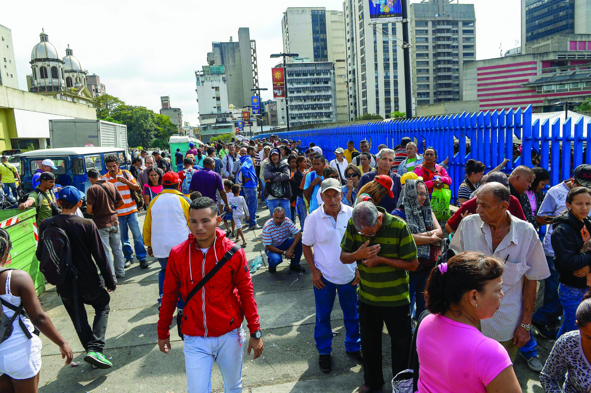 People queue outside Venezuela's Central Bank in Caracas to change 100 bolivar notes, yesterday.