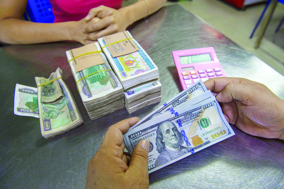 A money changer handles a transaction of US dollar and Myanmar Kyats at the Myanmar Central Bank.
