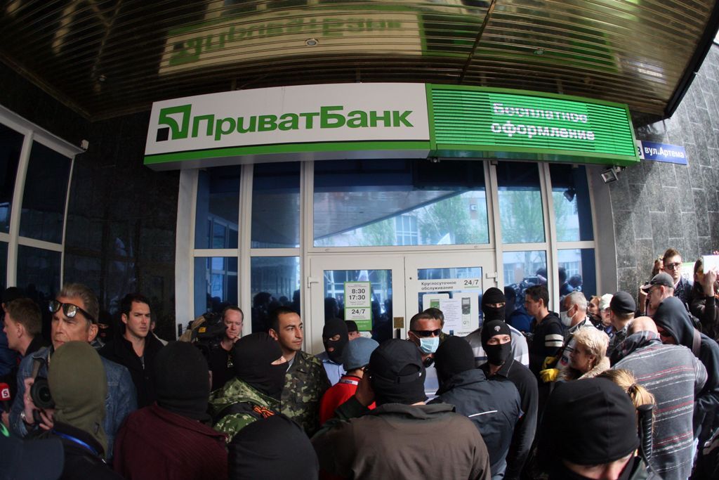 (FILES) This file photo taken on April 28, 2014 in the eastern Ukrainian city of Donetsk shows Pro-Russian militiants attacking a branch of Ukrainian bank Privatbank. Ukraine on December 18, 2016 nationalised the country's biggest bank in a bid to avert a
