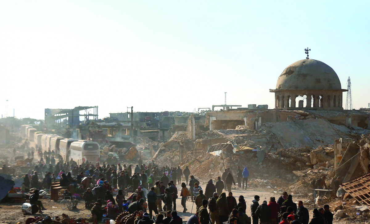 Syrians waiting to be evacuated from the east part of Aleppo, that had been under siege, at a crossing point in Amiriyah district of Aleppo, yesterday.