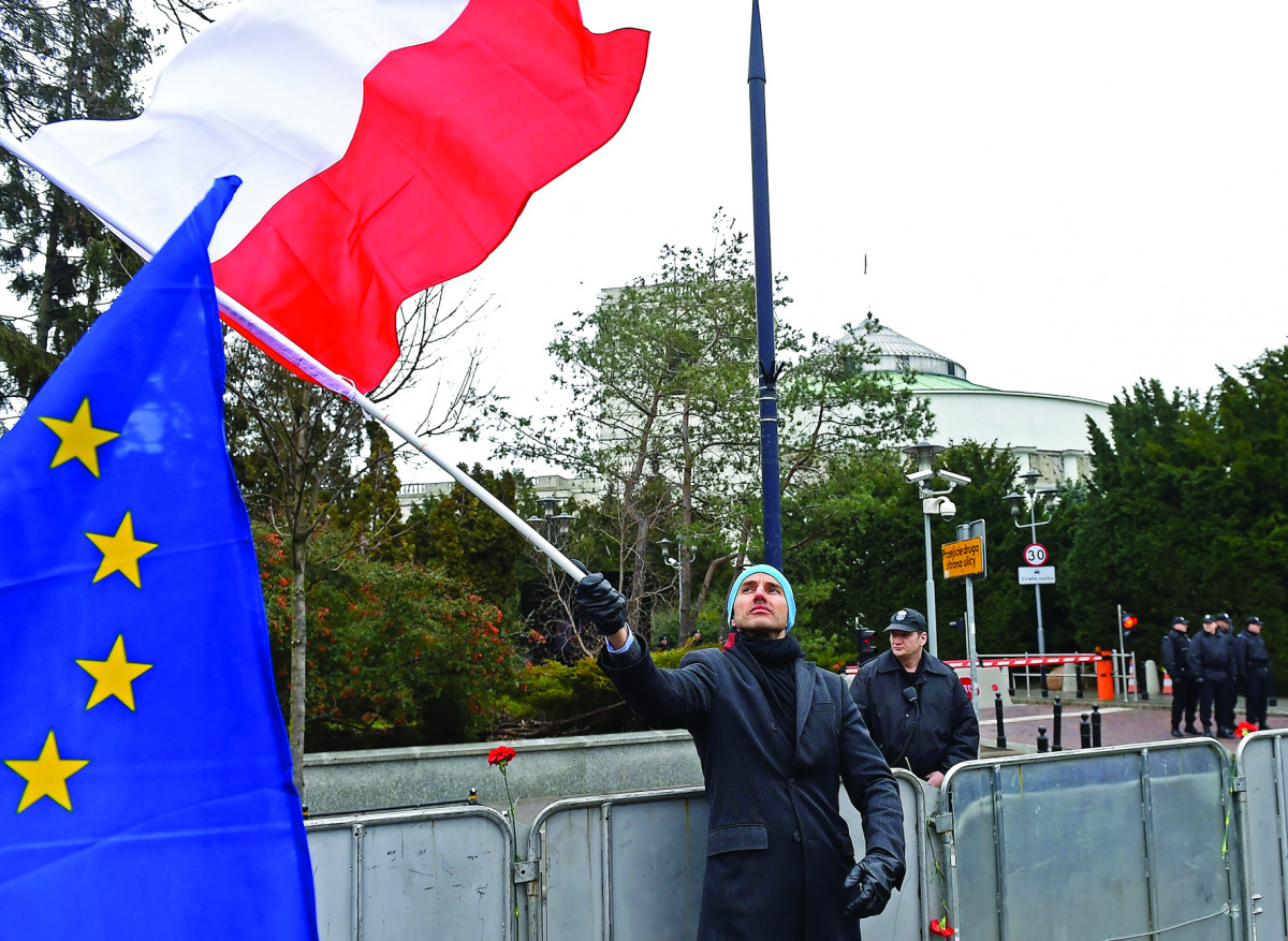 A man waves a Polish flag during an anti-government demonstration of opposition parties suporters and Committee for the Defence of Democracy movement (KOD) in Warsaw, yesterday.
