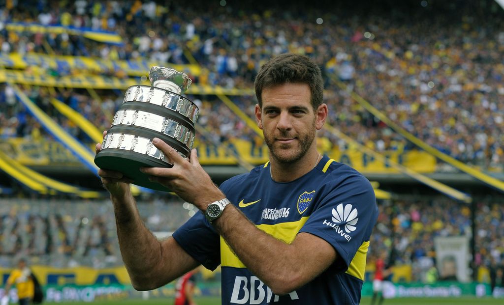 Argentinian tennis player Juan Martin del Potro holds a Davis Cup 2016 trophy replica while poseing for the photographer before the Argentina's First Division football match between Boca Juniors and Colon at La Bombonera stadium, in Buenos Aires, on Decem