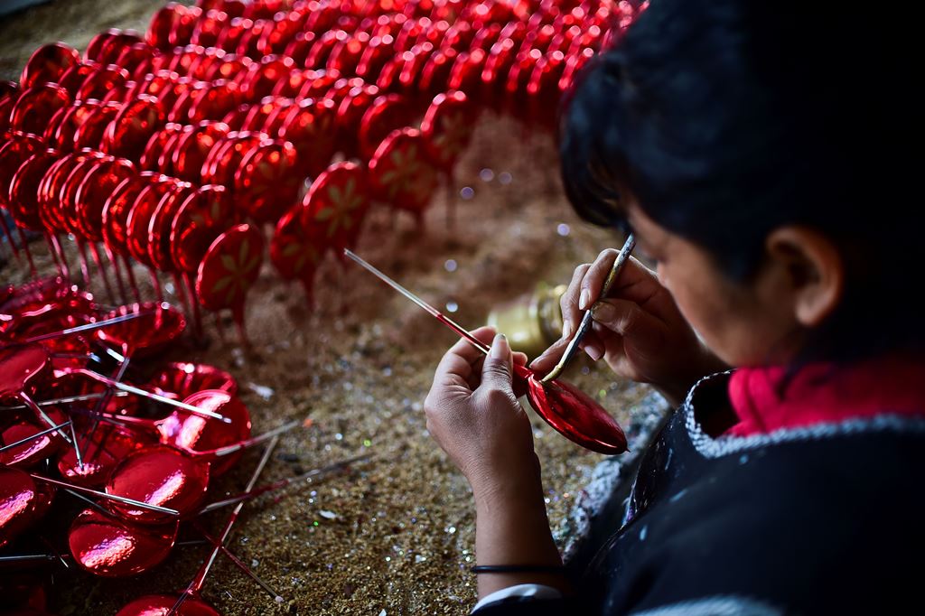 An employee makes Christmas ornaments at a factory in Tlapujahua, Michoacan State, Mexico, on December 16, 2016. Tlapujahua has several factories of Christmas ornaments, being this activity one of the most important for the economy of the town. / AFP / Ro