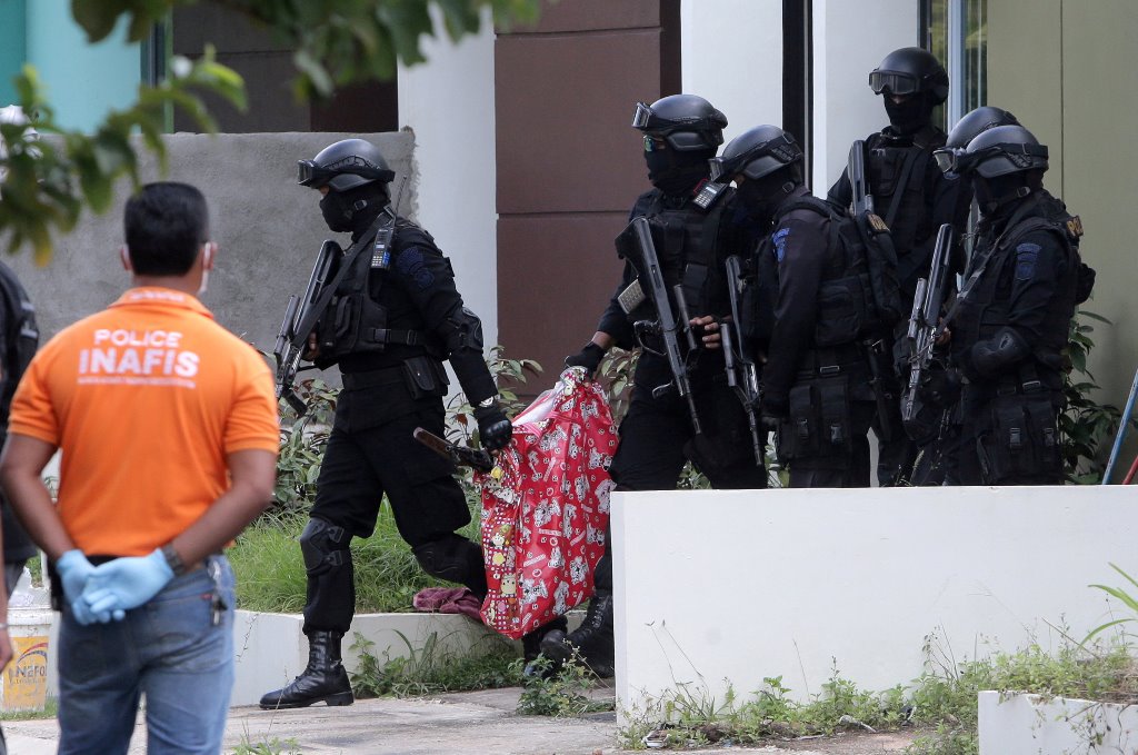 Indonesian anti-terror police from Detachment 88 carry a bag containing a suspected firearm and other evidence from a building during a raid in Batam, Riau Islands, Indonesia, August 5, 2016 in this photo taken by Antara Foto. Antara Foto/M N Kanwa/via RE