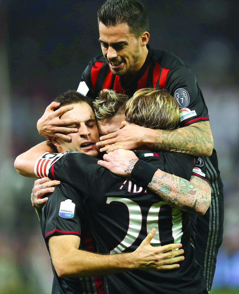 AC Milan's Giacomo Bonaventura (back) celebrates with teammates scoring a goal against Juventus' team during the Italian Super Cup final in Doha yesterday.