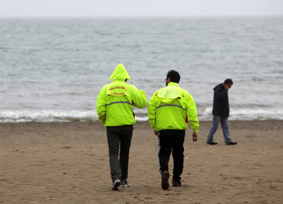Lifeguards walk on an evacuated beach in Penco town during a tsunami alert after a quake hit Chiloe island, southern Chile, December 25, 2016. REUTERS/Juan Gonzalez