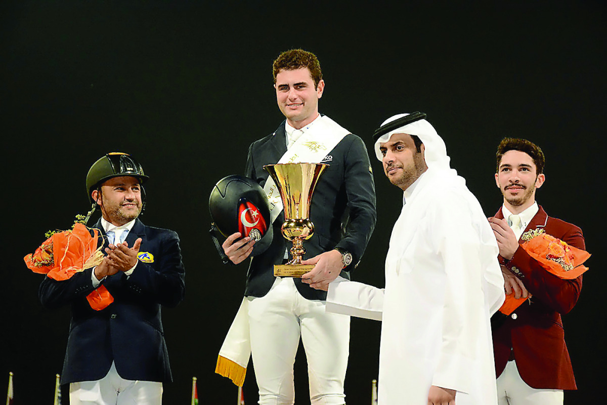 Turkish rider Derin Demirsoy, (centre) receives the trophy from QEF President Hamad Abdulrahman Al Attiyah after winning the QR 650,000 Grand Prix at the Qatar International Show Jumping Championship at the Qatar Equestrian Federation's (QEF) Main Arena o