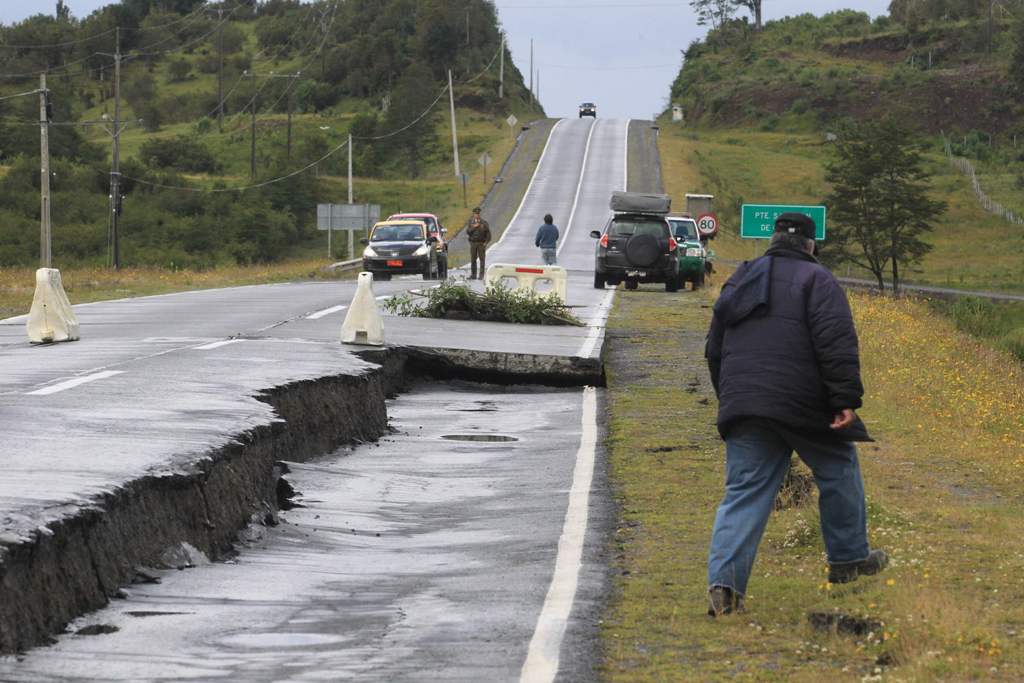 People inspect damage caused on highway 5 south on Chiloe Island off the Pacific coast of southern Chile, by a 7.7-magnitude earthquake on December 25, 2016. AFP / ALVARO VIDAL
