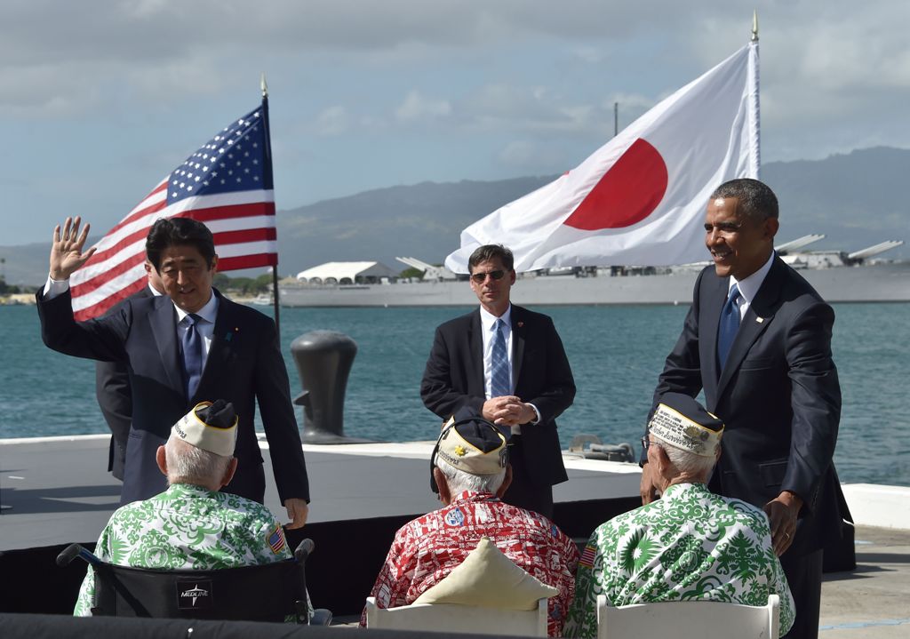 US President Barack Obama (R) looks on as Japanese Prime Minister Shinzo Abe greets veterans at Kilo Pier overlooking the USS Arizona Memorial on December 27, 2016 at Pearl Harbor in Honolulu, Hawaii. AFP / Nicholas Kamm
