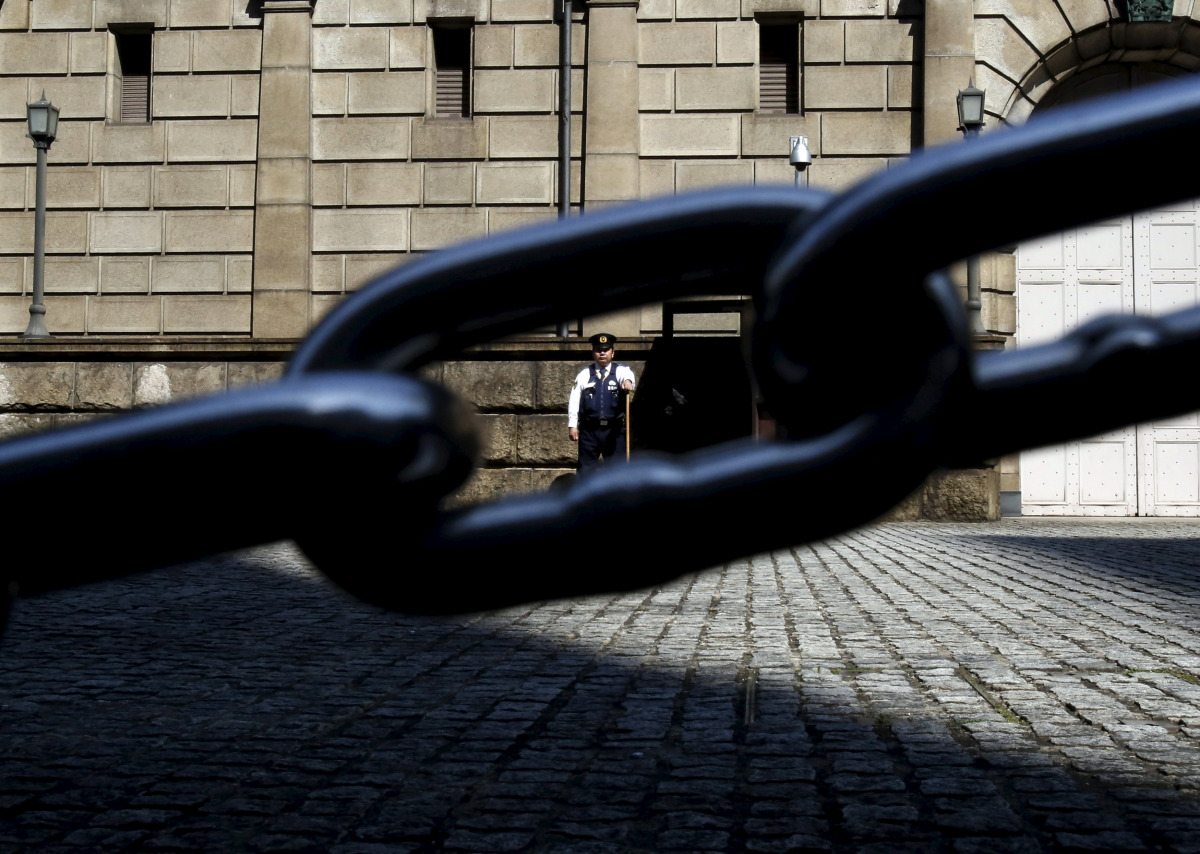 A security officer is seen through a chain link as he stands guard outside the Bank of Japan headquarters in Tokyo, March 31, 2016 (REUTERS / Yuya Shino) 
