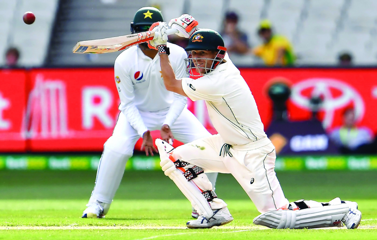 Australian batsman David Warner drives the ball on the way to his century against Pakistan on the third day of the second cricket Test match in Melbourne yesterday. 