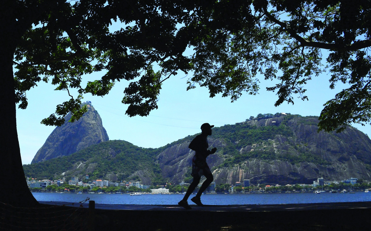 A man runs along Rio de Janeiro's promenade on December 28, 2016. The first summer days in Rio de Janeiro brought a heat wave that reached a windchill factor of 50 degrees Celsius. AFP / VANDERLEI ALMEIDA