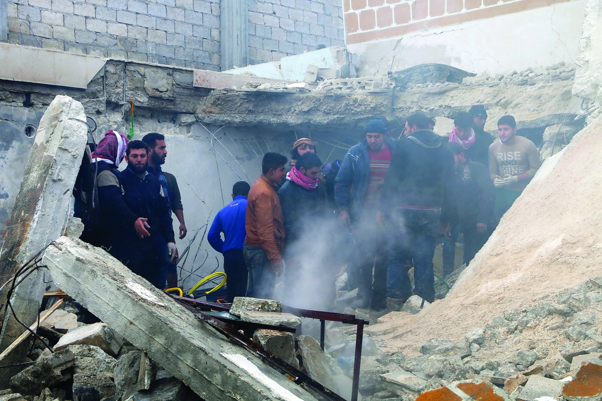 People watch rescue operations after a car bombing attack at the opposition controlled Soran district of Aleppo, yesterday. 