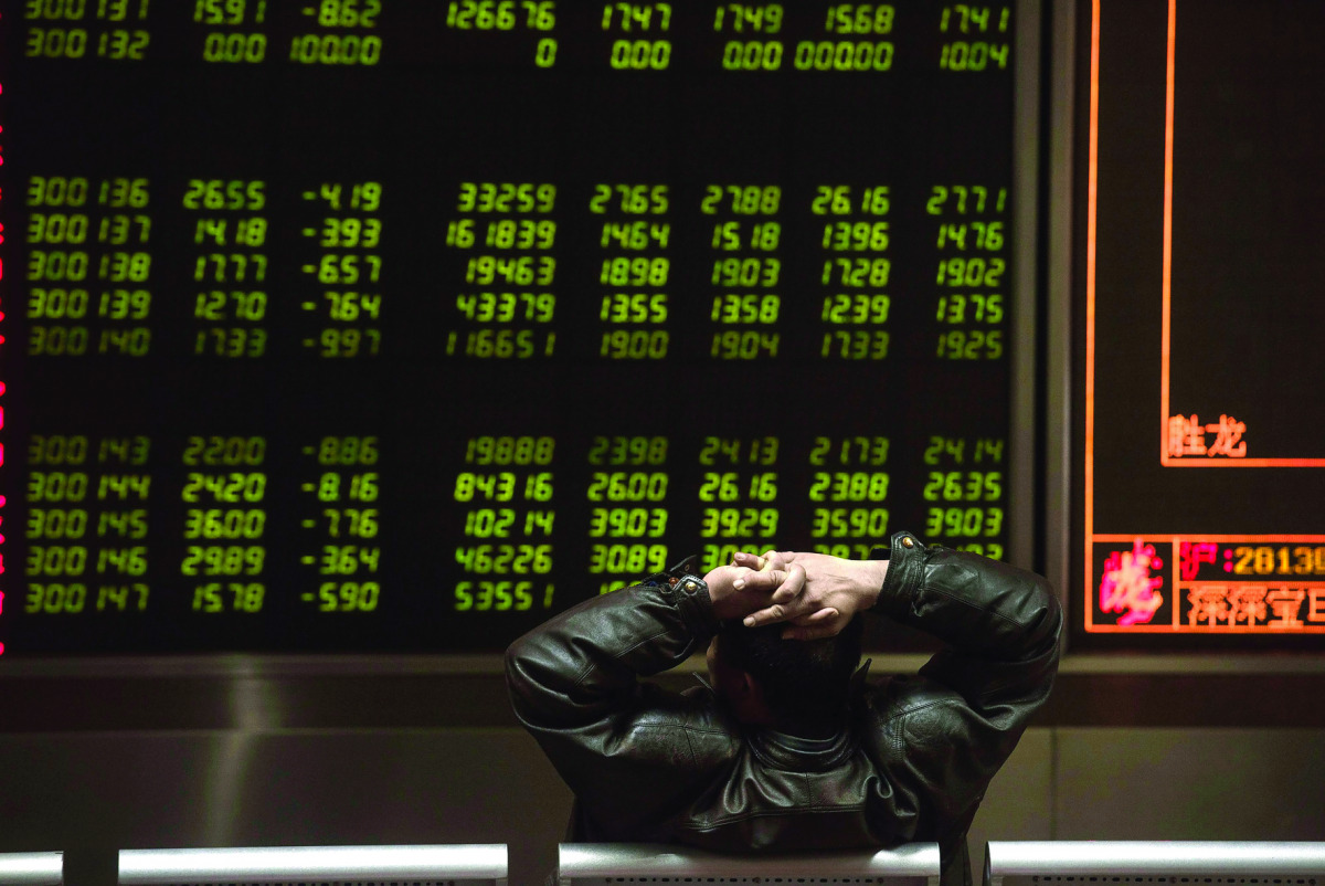 An investor watching stock prices on screens at a securities company in Beijing