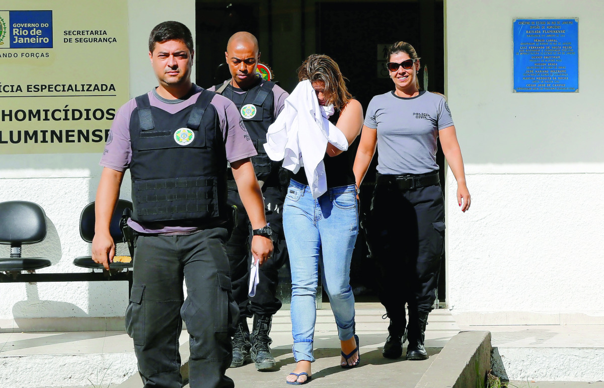 Francoise Souza Oliveira, wife of Greek Ambassador for Brazil Kyriakos Amiridis, is escorted by police as she is transferred from the police station to a jail in Brazil, yesterday.