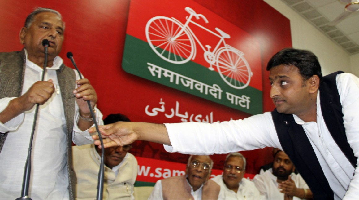 FILE PHOTO:  Akhilesh Yadav of Uttar Pradesh adjusts microphone for his father the Samajwadi Party President Mulayam Singh Yadav during a meeting in Lucknow March 10 2012 (Reuters) 