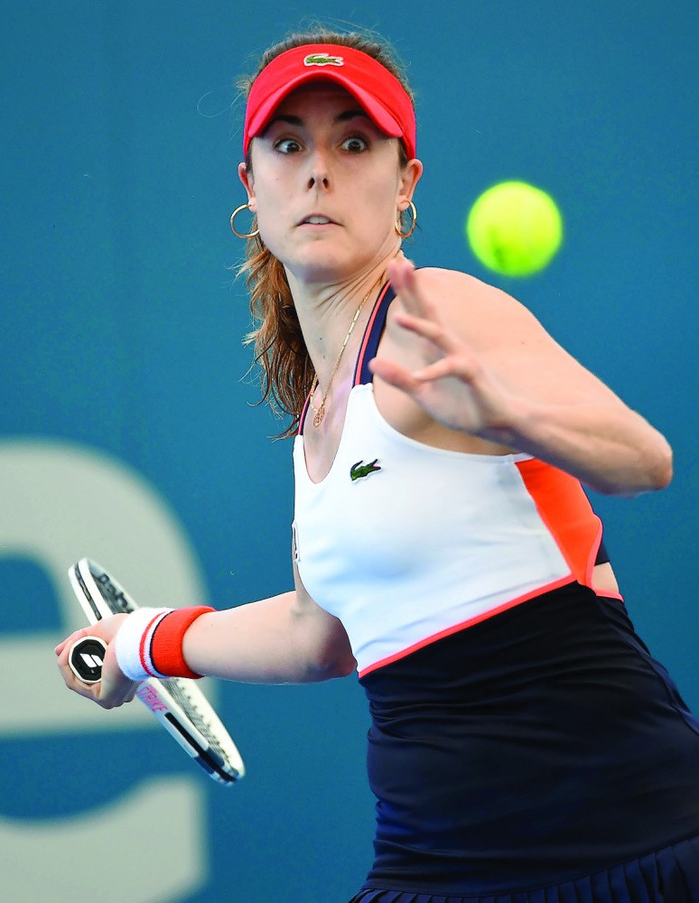 Alize Cornet of France hits a return against Elena Vesnina of Russia during the first round of the Brisbane International tennis tournament in Brisbane, Australia yesterday.