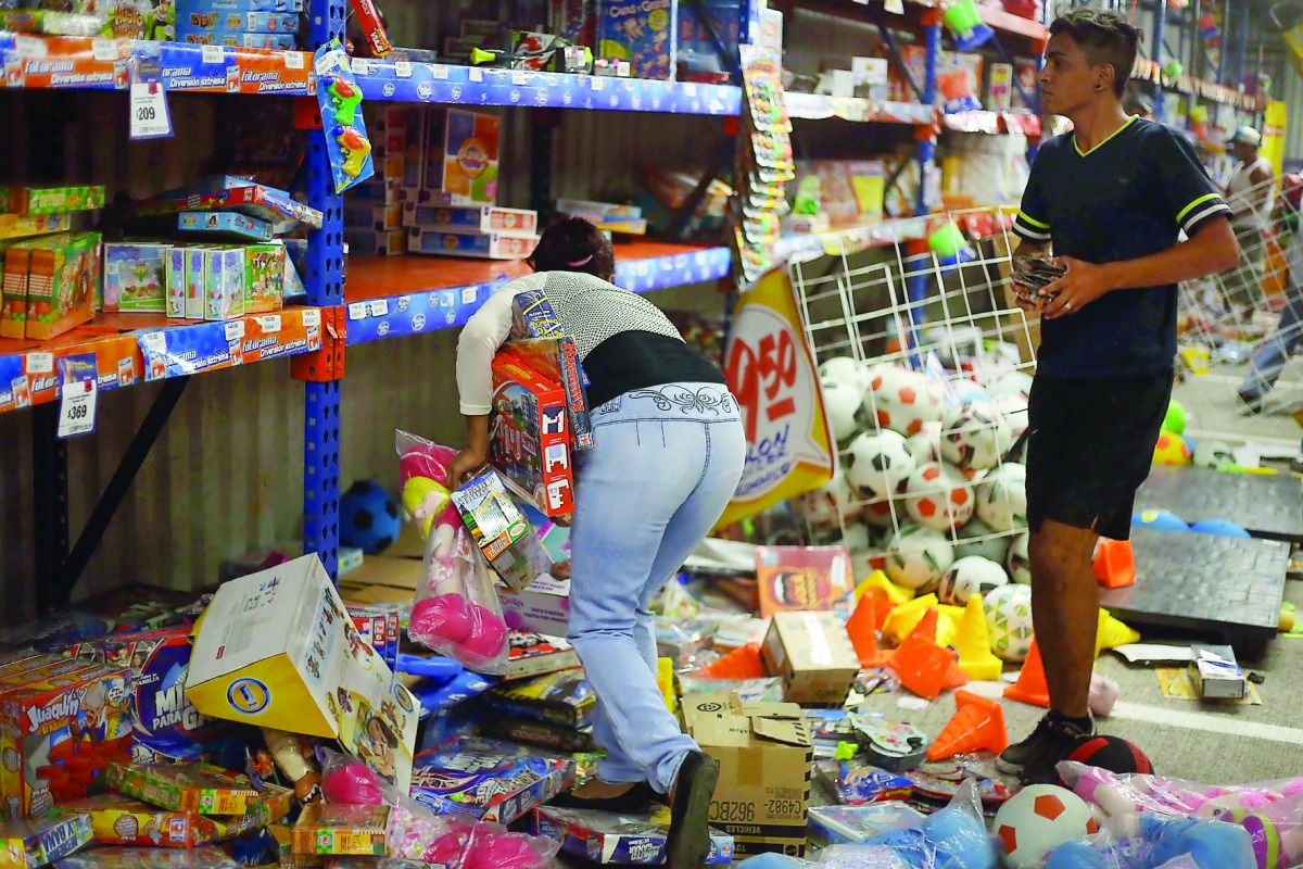 People pick up toys as they loot a store during a protest in the port of Veracruz, Mexico, yesterday.