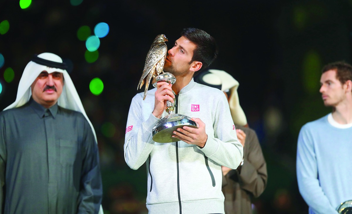 Serbia's Novak Djokovic poses with the ExxonMobil Qatar Open trophy after beating Britain's Andy Murray 6-3, 5-7, 6-4 in the final at the Khalifa International Tennis Complex in Doha yesterday