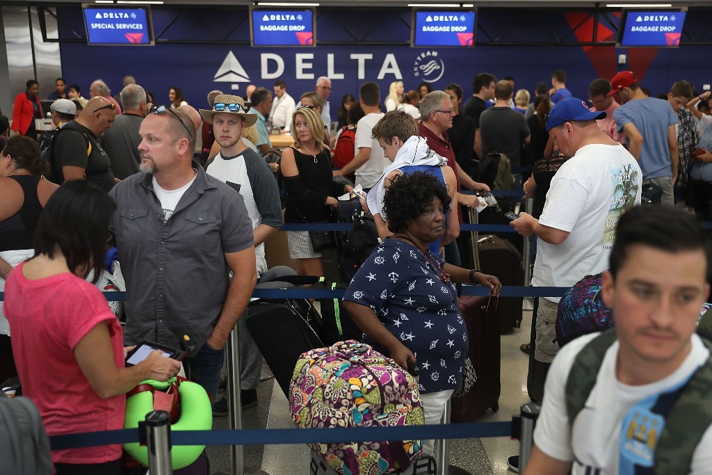 People stand in line as they wait for their flights at Terminal 2 where yesterday a shooter killed five people and wounded six others in the baggage area before he was taken into custody, at the Fort Lauderdale-Hollywood International airport on January 7
