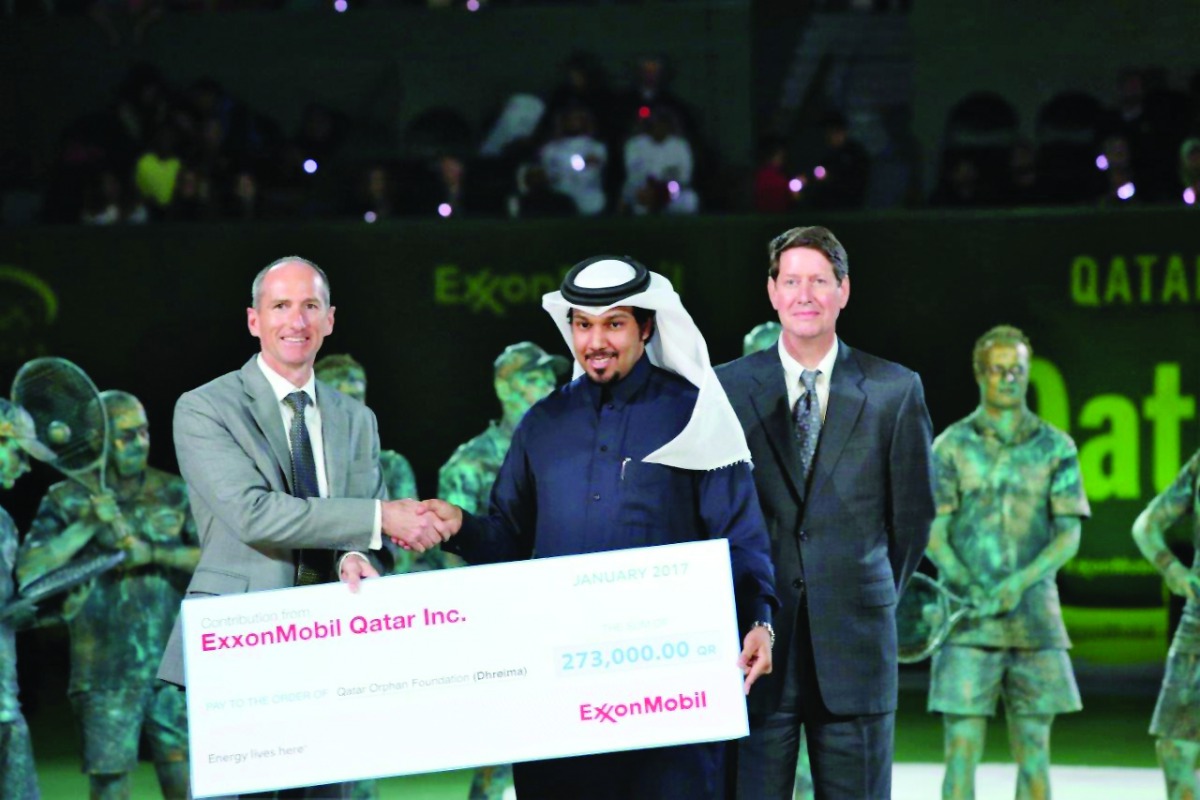 Alistair Routledge, President and General Manager for ExxonMobil Qatar, presenting the cheque to Ahmad Hussain, Director of Supporting Services for Dhreima during closing ceremony of the Qatar ExxonMobil Open Tennis Tournament at the Khalifa International
