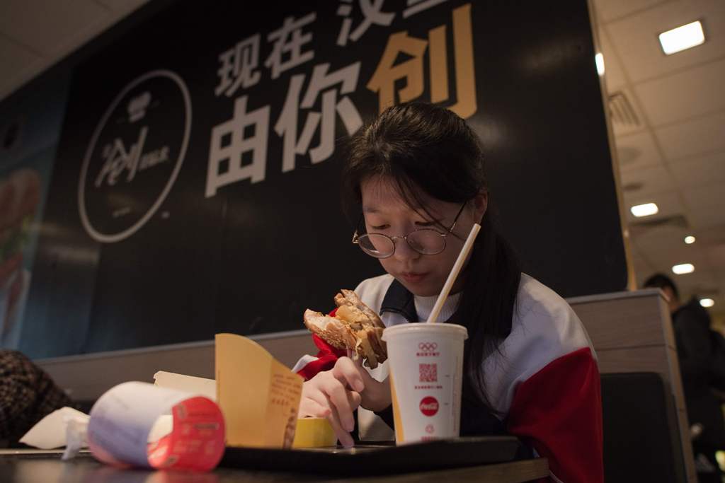 A Chinese customer eats a meal at a McDonald's fast food restaurant in Beijing on January 9, 2017. AFP / NICOLAS ASFOURI
