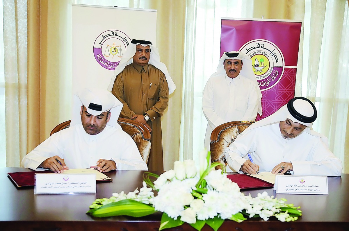 Minister of Transport and Communications H E Jassim bin Saif Al Sulaiti (standing right) and Head of the Court of Cassation and President of the Supreme Judiciary Council, Masoud Mohamed Al Amirthe, witnessing the signing of a Memorandum of Understanding 