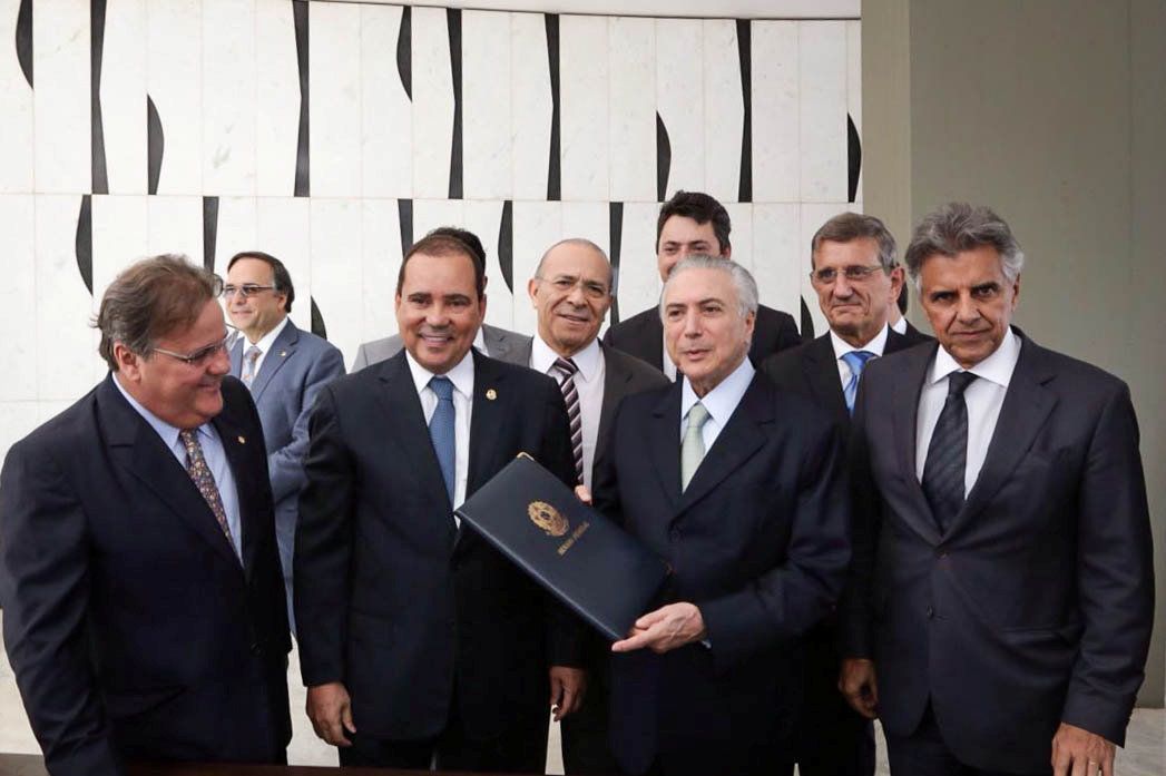 Michel Temer holds a folder with a document notifying him of becoming the interim president at his Jaburu Palace official residence in Brasilia, May 12, 2016 (Reuters) 