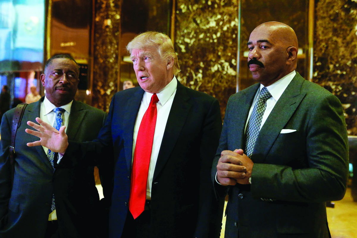 US President-elect Donald Trump speaks to members of media with television personality Steve Harvey (right) and businessman Greg Calhoun after their meeting at Trump Tower in New York, yesterday.