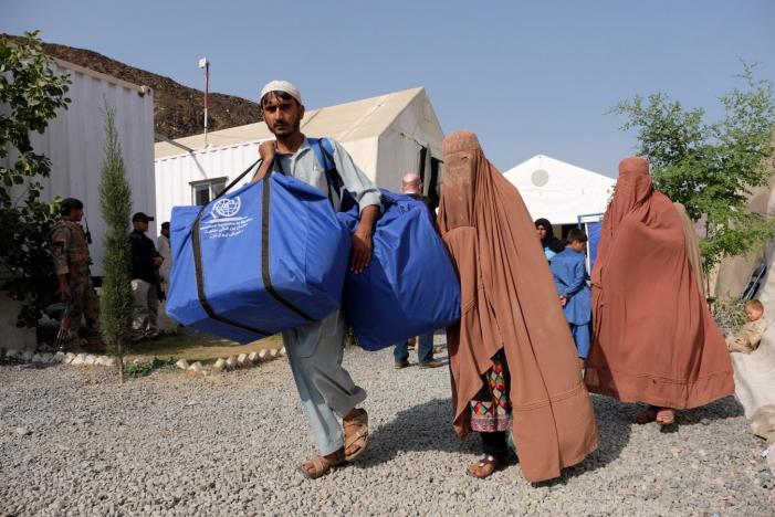 An Afghan family who were living as refugees in Pakistan carries bundles of supplies at a humanitarian aid station in Torkham, Afghanistan, October 22, 2016 (REUTERS / Josh Smith) 