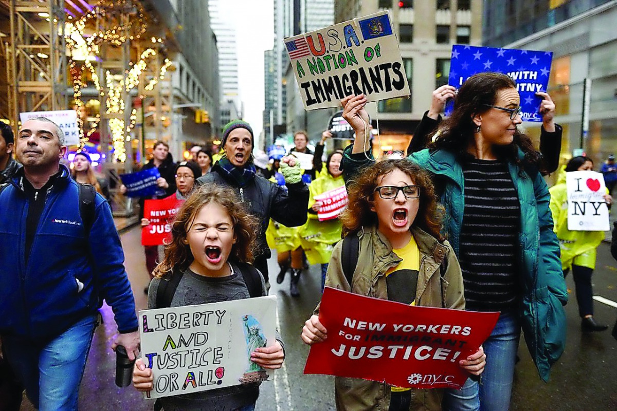 People march towards Trump Tower during a protest organised by the New York Immigration Coalition against President-elect Donald Trump in New York. 