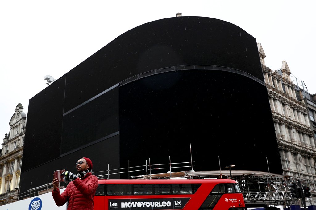 A double decker bus passes the advertisement boards at Piccadilly Circus which have been switched off prior to being replaced with more modern screens, in central London, Britain January 16, 2017. REUTERS/Stefan Wermuth,
