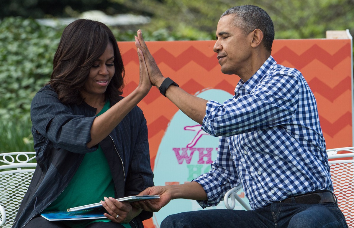 Barack Obama and Michelle Obama high five each other after reading 