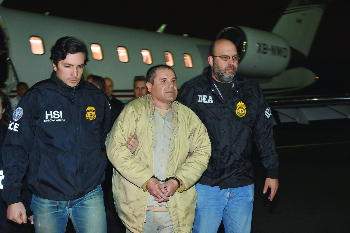 Mexico's top drug lord Joaquin “El Chapo” Guzman is escorted as he arrives at Long Island MacArthur airport in New York, yesterday.