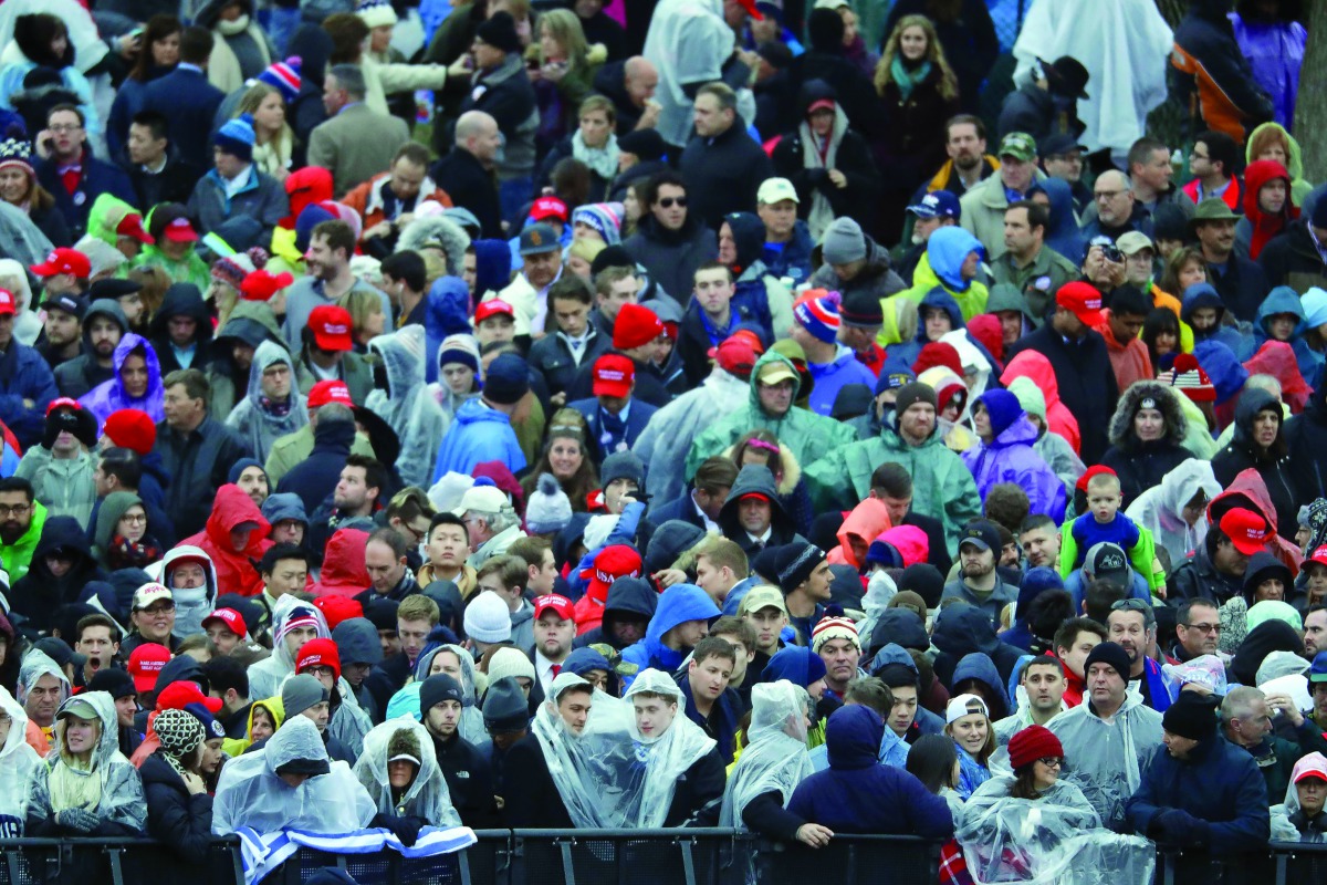 Supporters in rain gear gather in front of US Capitol, at the inauguration of President Donald Trump.