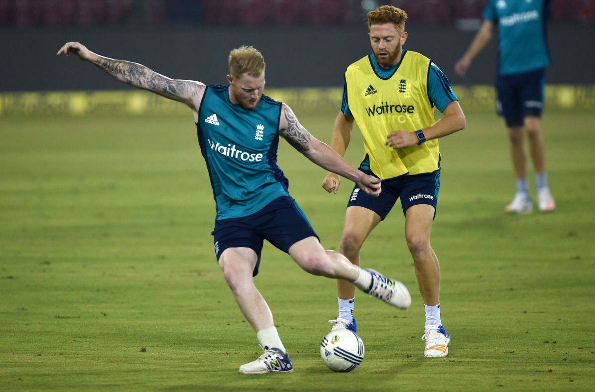 England's Jonny Bairstow (R) and Ben Stokes kick a ball during a training session at the Barabati stadium in Cuttack on January 18, 2017. (AFP / Money SHARMA)