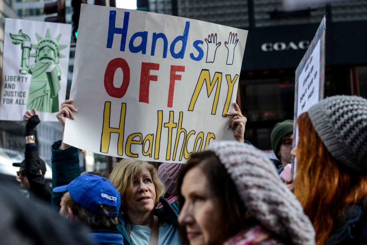 A woman holds a sign reading 
