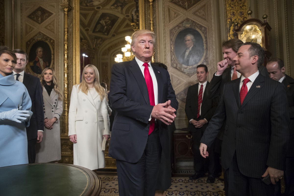 President Donald Trump leaves the President’s Room of the Senate at the Capitol after he formally signed his cabinet nominations into law, in Washington, USA on January 20, 2017. At far right is Chief of Staff Reince Priebus, with White House counsel Dona