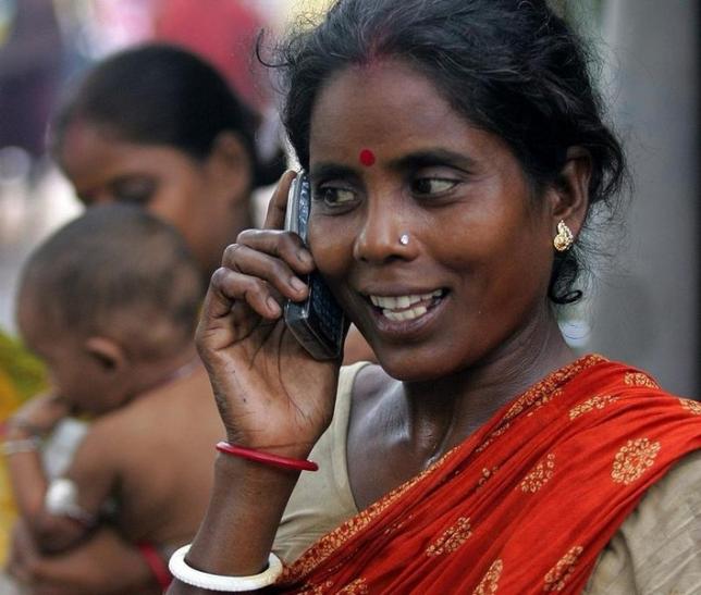 Tulsi Prasad, an Indian slum dweller, uses a mobile phone in the eastern Indian city of Kolkata, August 23, 2005 (Reuters)